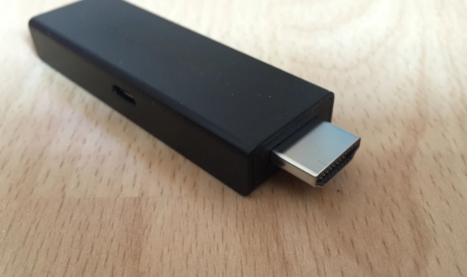 Clé de streaming posée sur un bureau, connecteur HDMI et prise d’alimentation visibles